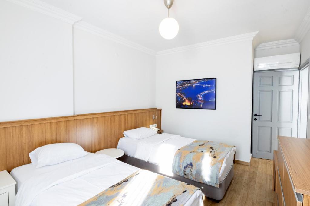 twee bedden in een kamer met witte muren bij Comfort Suites in Alanya