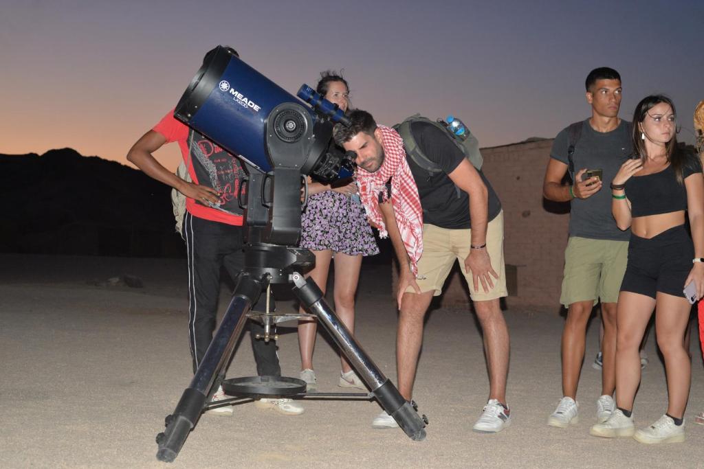 un grupo de personas de pie alrededor de una cámara en Hurghada Desert stargazing en Hurghada