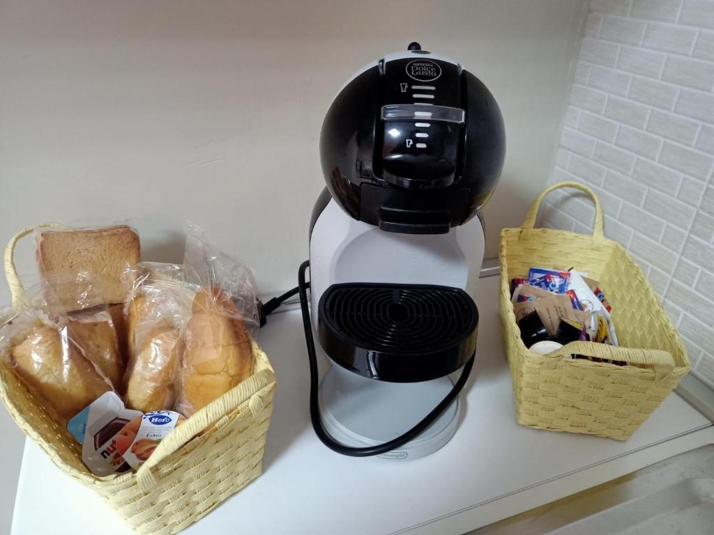 a black and white blender next to a basket of bread at Mary's House in SantʼEufemia Lamezia