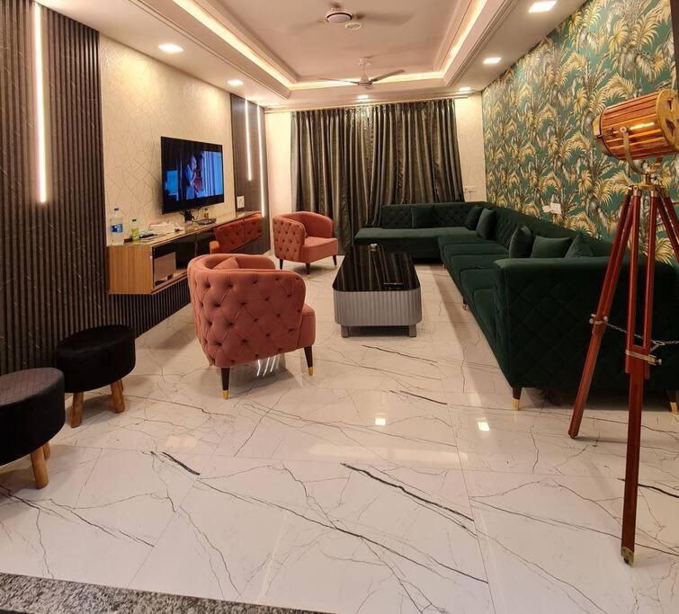 a large living room with green couches and chairs at Rosset-57, Cosy Stay & luxury party place in Faridabad