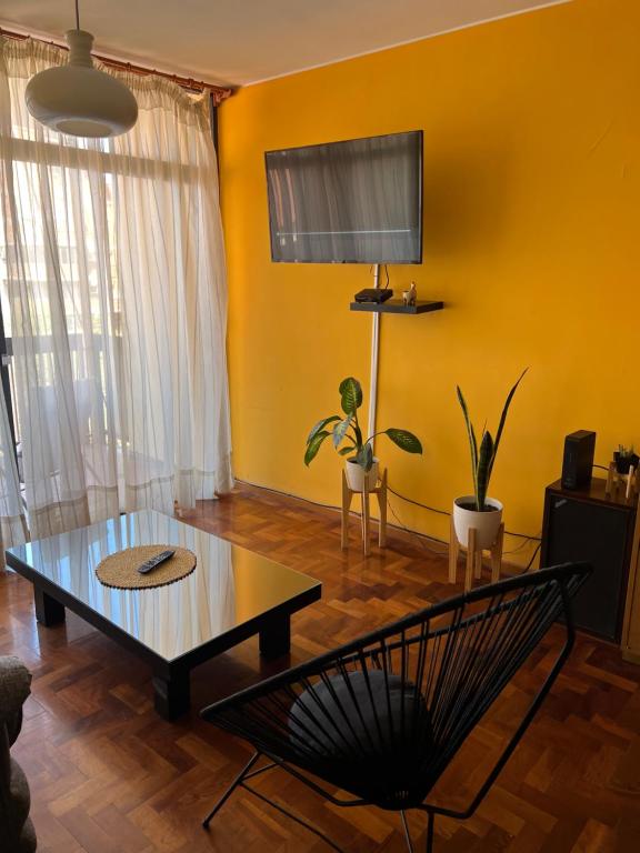 sala de estar con mesa y pared amarilla en Departamento en pleno centro con cochera en Mendoza
