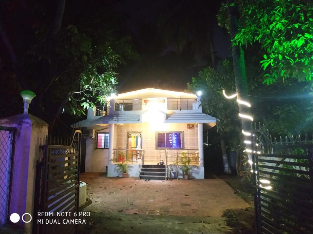 una casa con luces en la parte delantera de la noche en Krushna Kunj Holiday Home, en Alibaug
