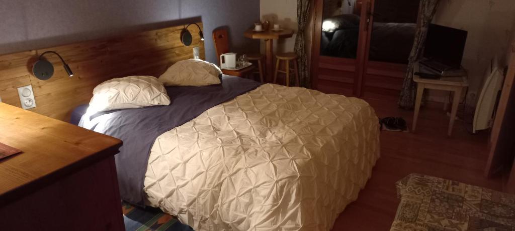 1 dormitorio con 1 cama grande y cabecero de madera en L'Eterlou Chambres d'Hote, en Albertville