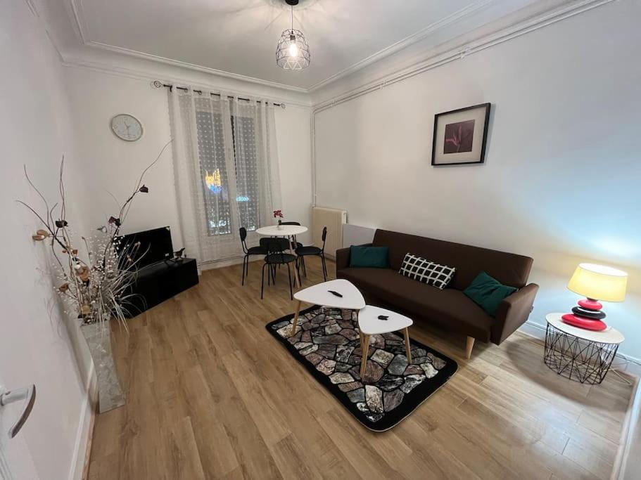 ein Wohnzimmer mit einem Sofa und einem Tisch in der Unterkunft Appt 2ch, gare 2 mn, Paris 15 mn in Villeneuve-Saint-Georges
