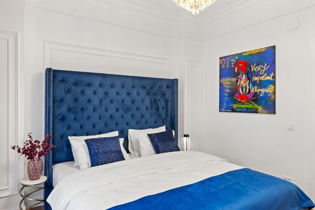 un dormitorio con una cama con cabecero azul en Apartament - Rafinament Arhitectural - Blocul Wilson, en Bucarest