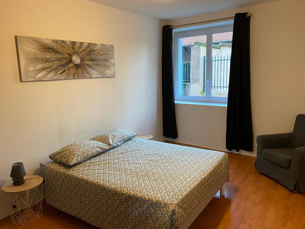 um quarto com uma cama, uma janela e uma cadeira em Maison proche Lyon Centrale du Bugey em Dagneux