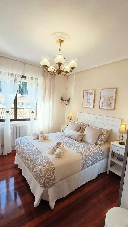 a bedroom with a large bed with two stuffed animals on it at Mar y Sol in Bermeo
