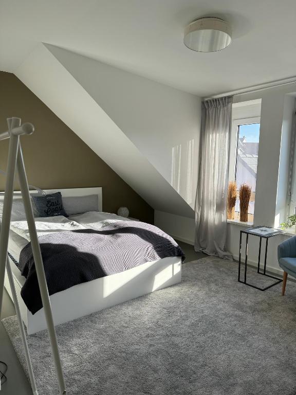 Habitación blanca con cama y ventana en Gemütliche Wohnung mit 2 Schlafzimmern auf 75 qm, en Kürnach