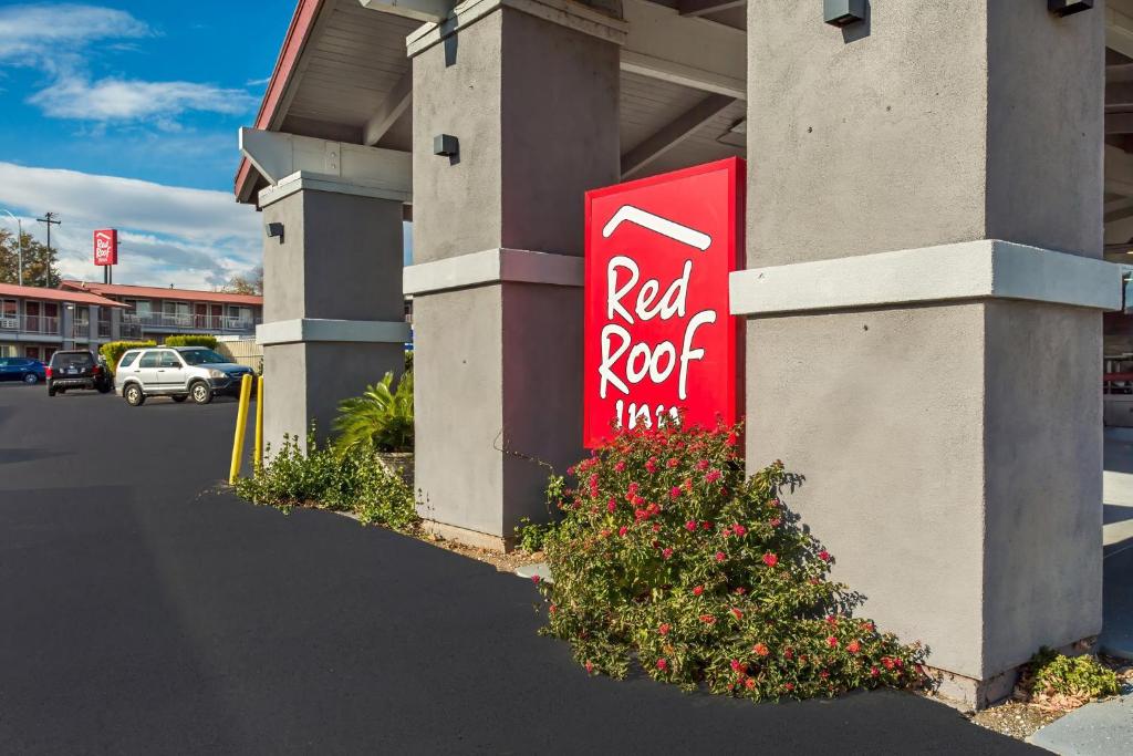 a red coke sign on the side of a building at Red Roof Inn Redding in Redding