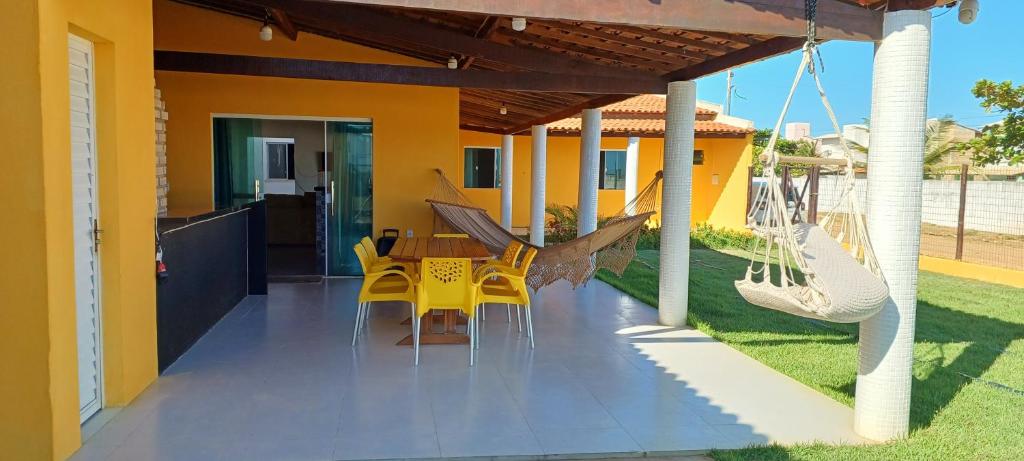 a patio with a table and chairs on a house at Casa de praia in Estância