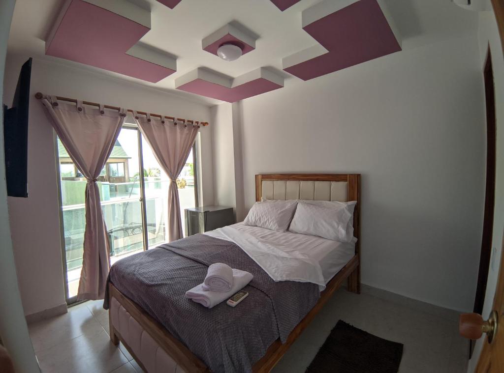卡塔赫納的住宿－Hotel Dreimar，一间卧室配有一张紫色天花板的床