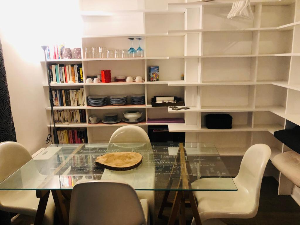 comedor con mesa de cristal y sillas en Habitation CASSIOPEE en París