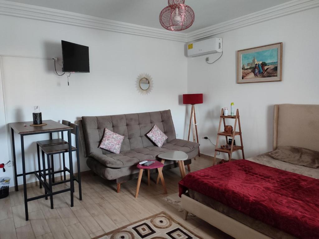 1 dormitorio con 1 cama, 1 sofá y 1 silla en appartement S+0 en Túnez