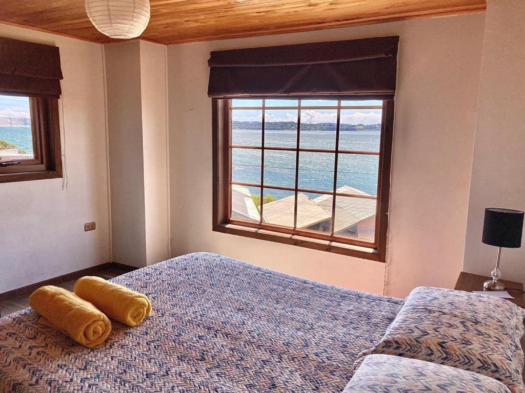 een slaapkamer met een bed en een groot raam bij Habitación privada 1, vista al mar , Casa familiar in Ancud