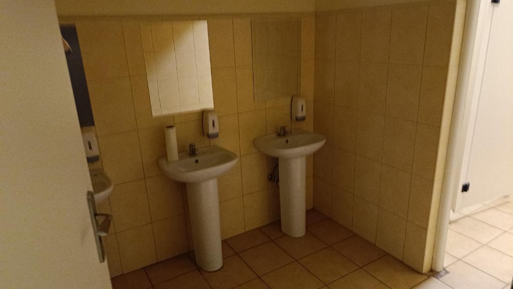 ein Badezimmer mit zwei Waschbecken in einem öffentlichen WC in der Unterkunft MeeMo 1 - hostel dla Firm in Łyszkowice