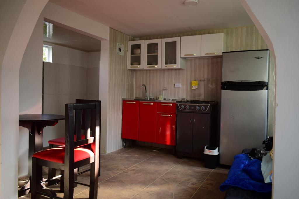 a kitchen with a red refrigerator and a red chair at Cabaña Maribel encanto in Filandia