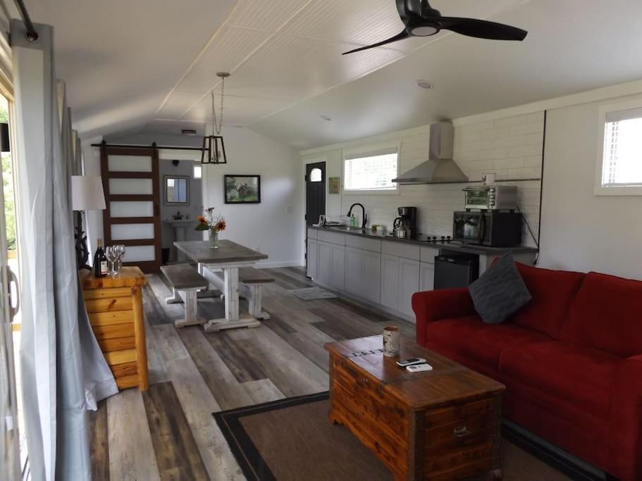 sala de estar con sofá rojo y cocina en The Ranch in Mt Airy, en Mount Airy
