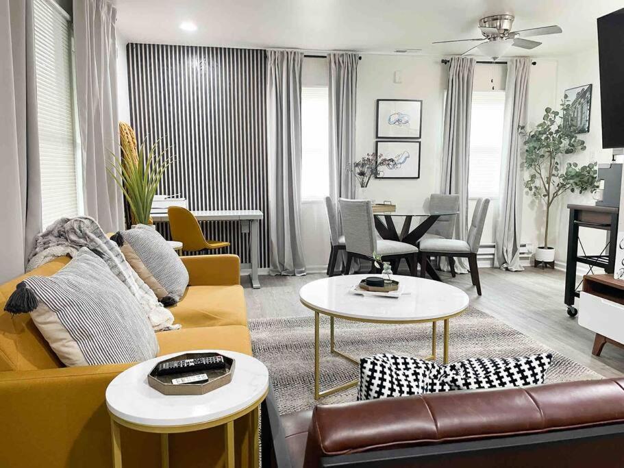 a living room with a yellow couch and tables at Casa Mila Downtown Indianapolis in Indianapolis