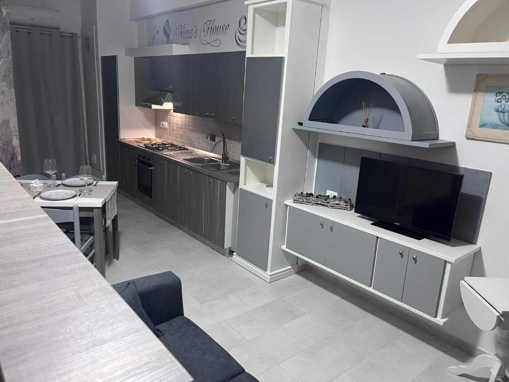 cocina grande con TV y mesa con mesa en Nina's house 3 , a 300 metri dal mare, en Santa Caterina Dello Ionio Marina