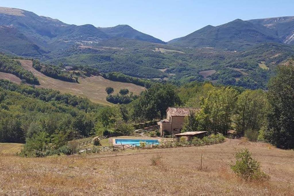a house with a swimming pool on a hill with mountains at Luxury Villa with Pool, Stunning Location in San Ginesio