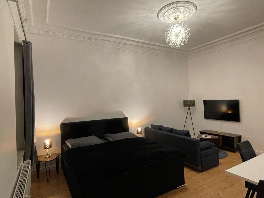 - un salon avec un canapé et une télévision dans l'établissement Leipzig City Apartment - Südperle - direkt im Geschehen, à Leipzig