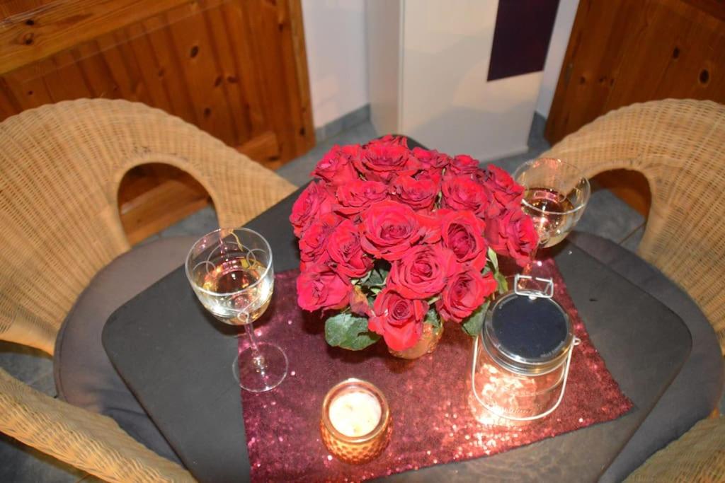 une table avec un bouquet de roses rouges et de bougies dans l'établissement Kleine einzigartige Ferienwohnung auf dem Bauernhof, direkt in der Natur mit Blick auf Schloss Braunfels, à Braunfels
