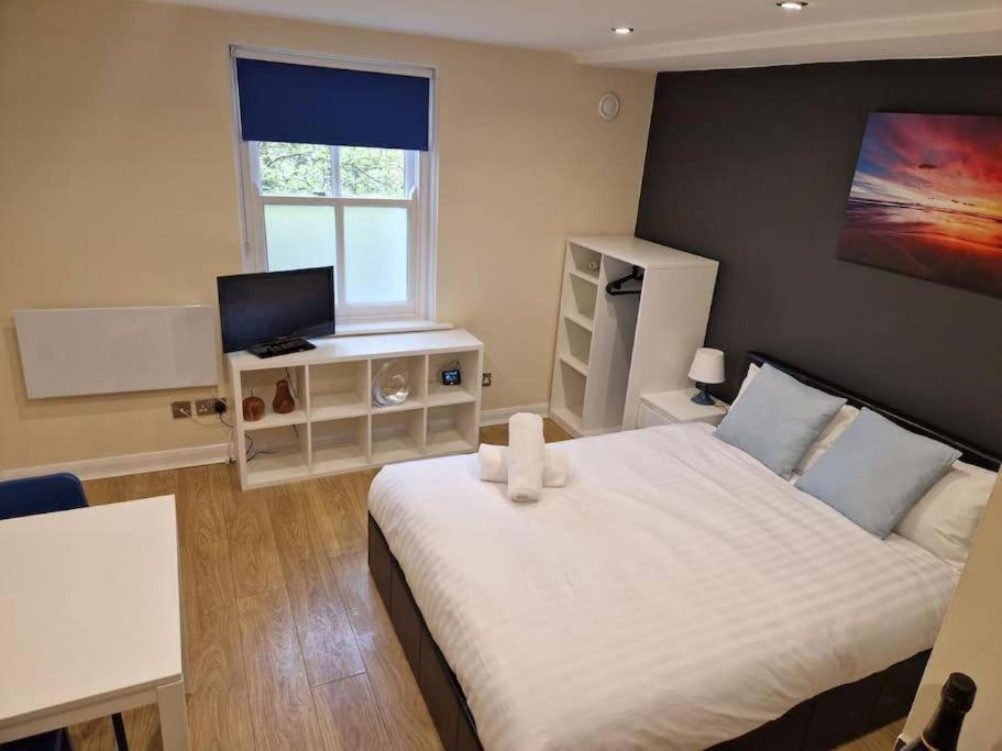 um quarto com uma cama branca e uma janela em Tranquil Studio Apartment em Blandford Forum