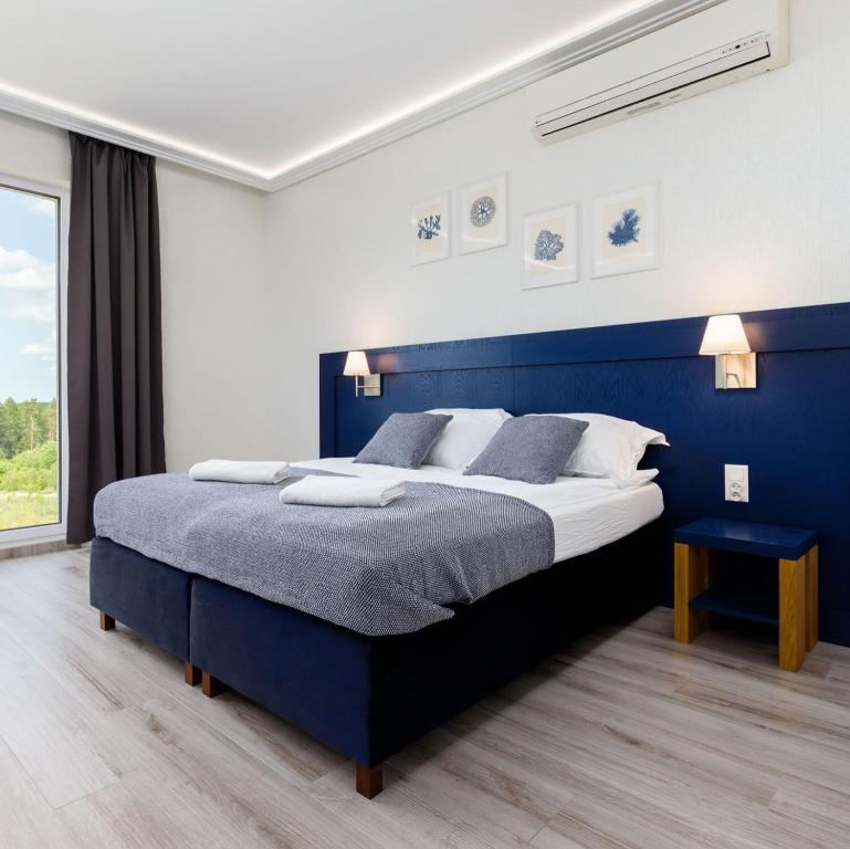 - une chambre bleue et blanche avec un grand lit dans l'établissement Nowoczesne apartamenty Jezioro Ukiel Zatoka Miła Plaża Miejska, à Olsztyn