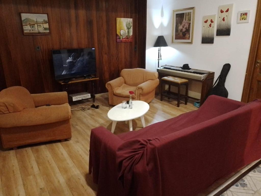 a living room with a couch and a table and a piano at San Telmo Hostel in Buenos Aires