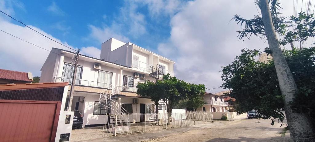 un bâtiment blanc avec une clôture devant lui dans l'établissement Recanto do Valtinho, à Florianópolis