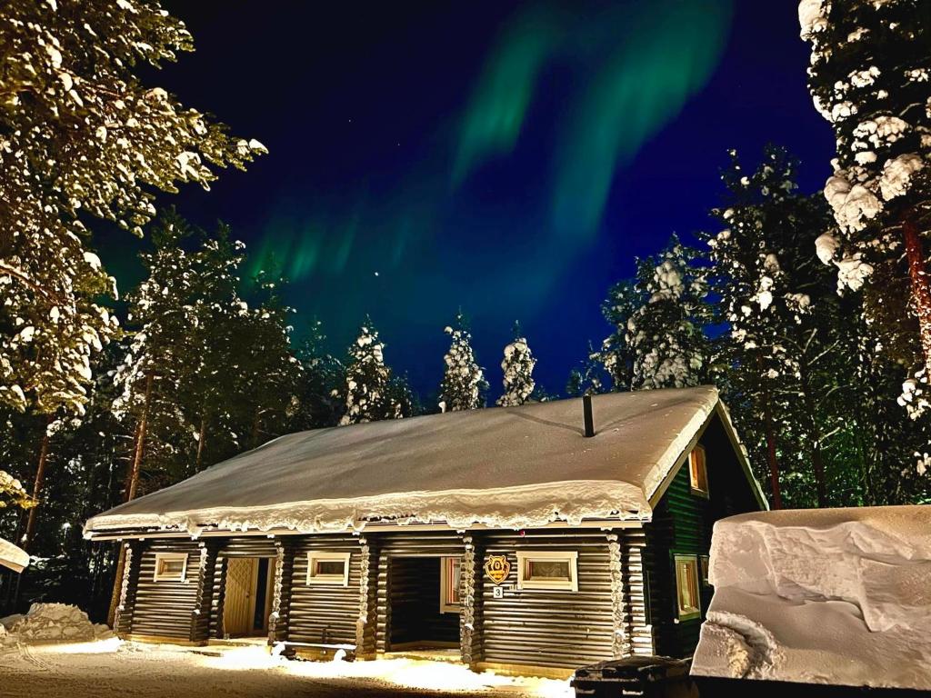 an old cabin with the aurora in the sky at Levillenet Bearlodge at Levi city centre in Levi