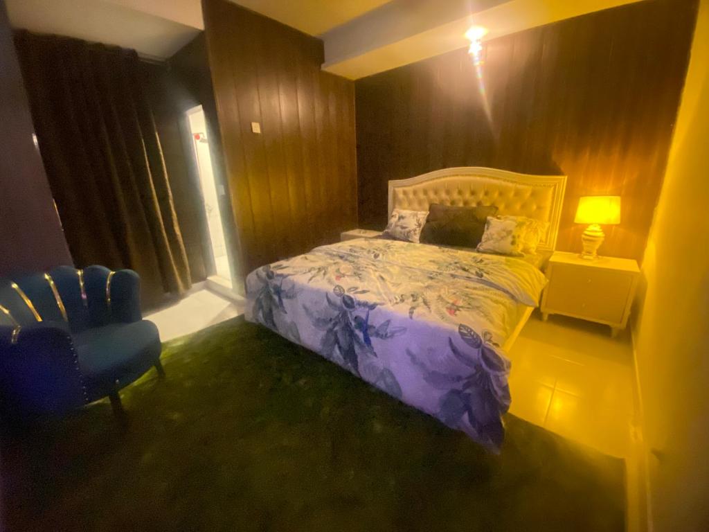 een slaapkamer met een paars bed en een blauwe stoel bij Viceroy Executive Hotel Apartments Islamabad in Islamabad