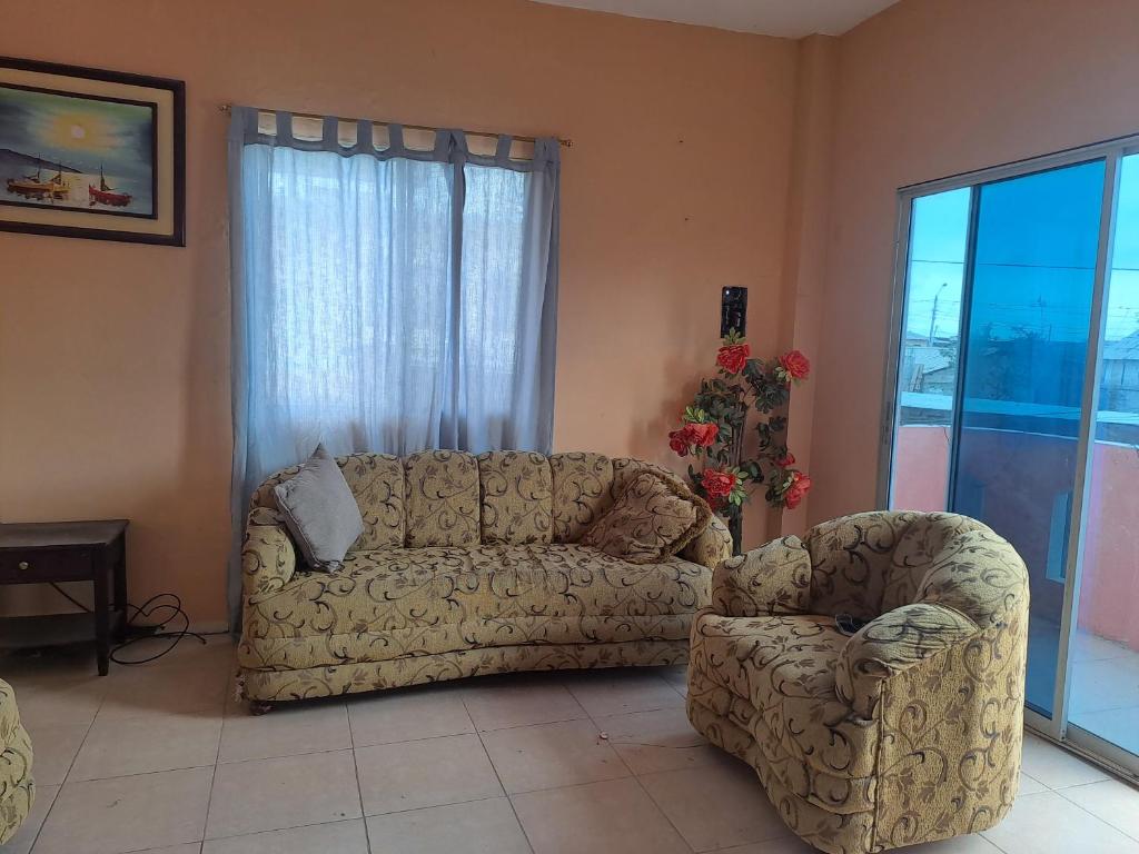 a living room with a couch and a chair at Hospedaje Playa y Arena in Playas