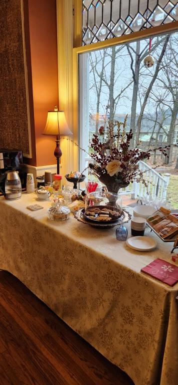 een tafel met een vaas met bloemen erop bij Oaklawn Inn in Menomonie