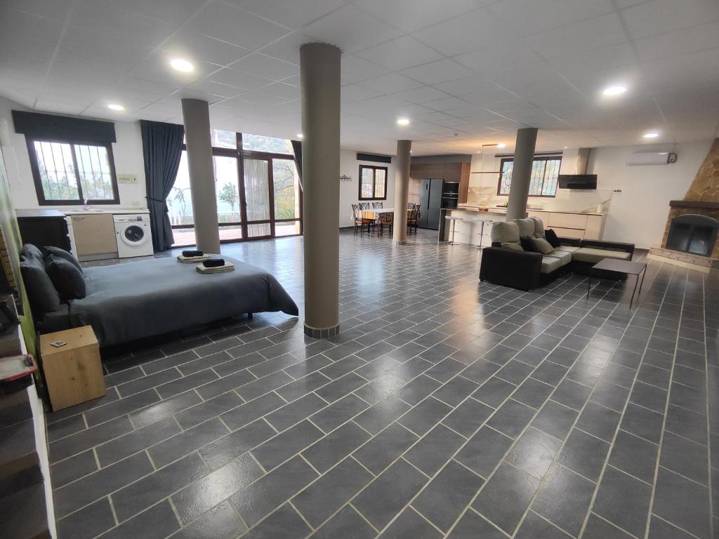 une grande chambre avec un lit et un salon dans l'établissement Casa Rural Sierra de las Nieves 2, à Tolox