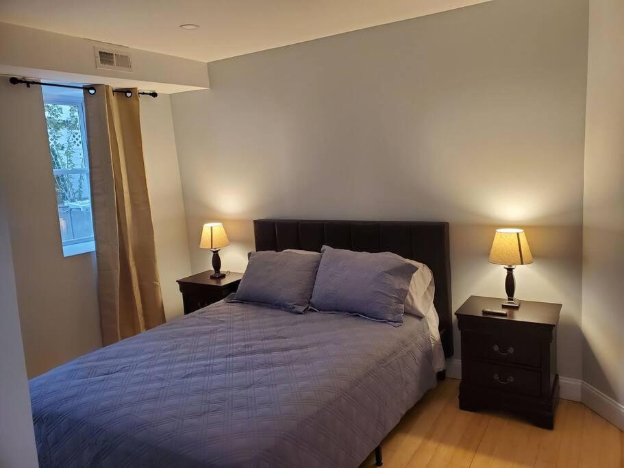 a bedroom with a bed and two lamps on tables at Casa Bella in North Bergen