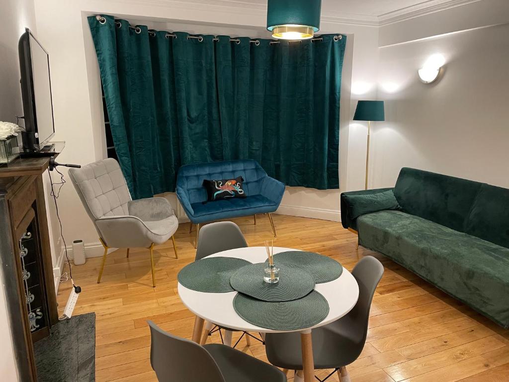 a living room with a green couch and a table at Superb 2 Bedrooms Ealing Broadway Apartment next to Tube & Buses in Ealing