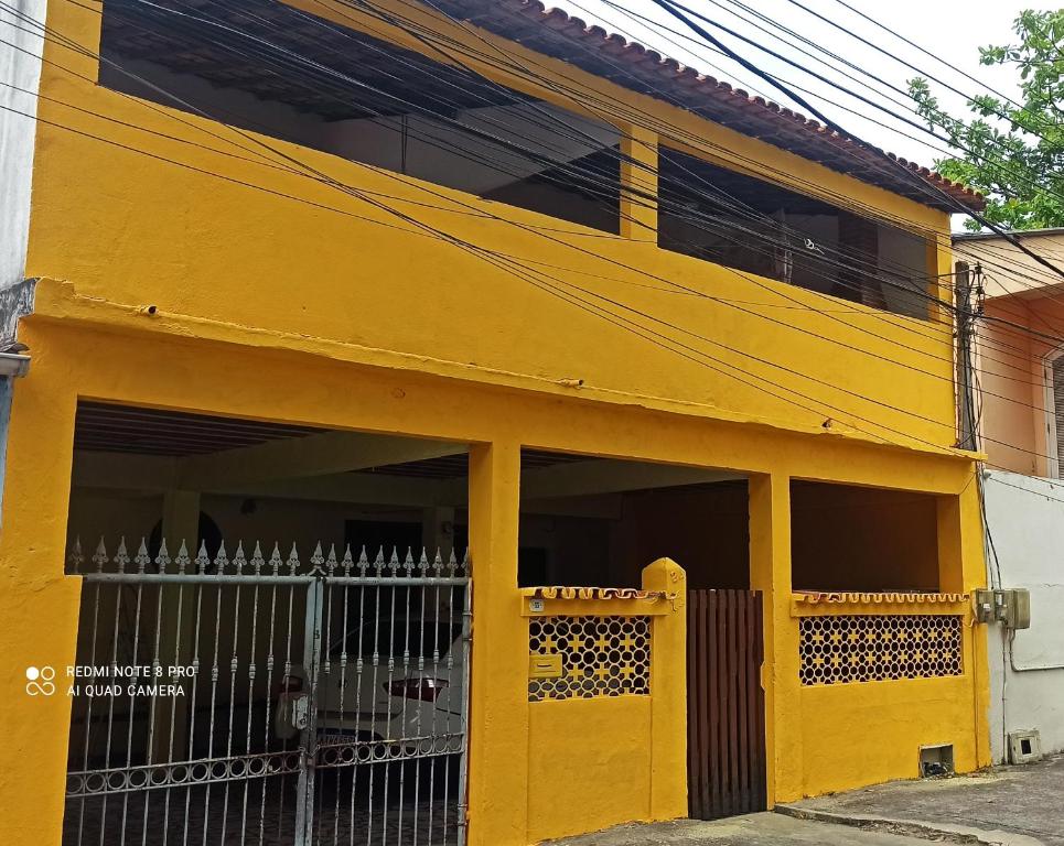 ein gelbes Gebäude mit einem Tor davor in der Unterkunft A casa amarela in Cabo Frio