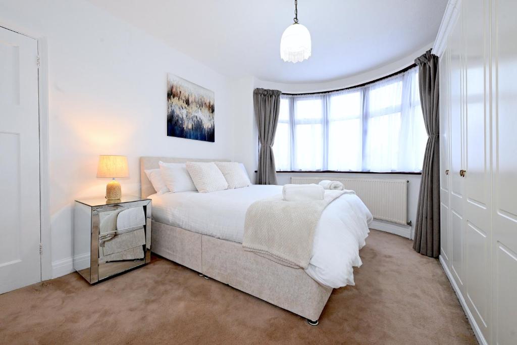 Un dormitorio blanco con una cama grande y una ventana en Home from home Retreat en The Hyde