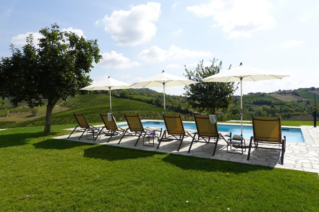 - un groupe de chaises longues et de parasols à côté de la piscine dans l'établissement Casa Faretto, à Costigliole dʼAsti