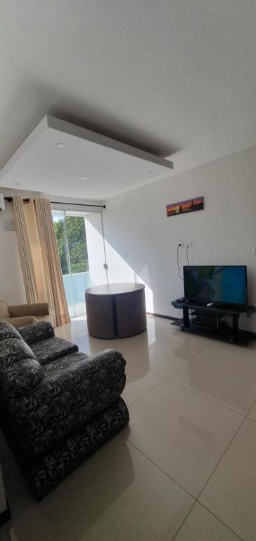 ein Wohnzimmer mit einem Sofa und einem Flachbild-TV in der Unterkunft Condominio Atlas in Santa Cruz de la Sierra