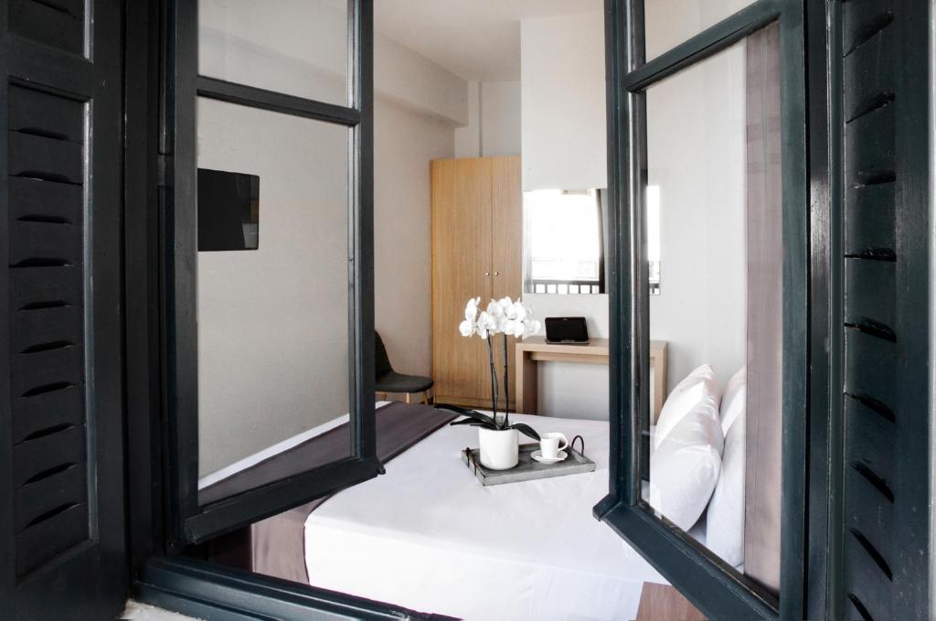 Cette chambre comprend un lit avec un grand miroir. dans l'établissement Atlas Suites, à Skiathos Chora