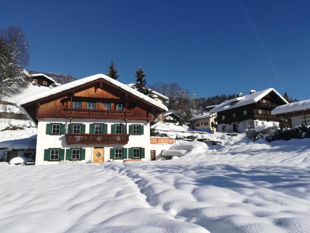 una casa cubierta de nieve con una carretera delante de ella en For 2, en Hopfgarten im Brixental