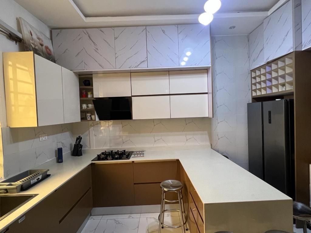 uma cozinha com armários brancos e uma bancada em Fowaa Lux em Mlichakpo
