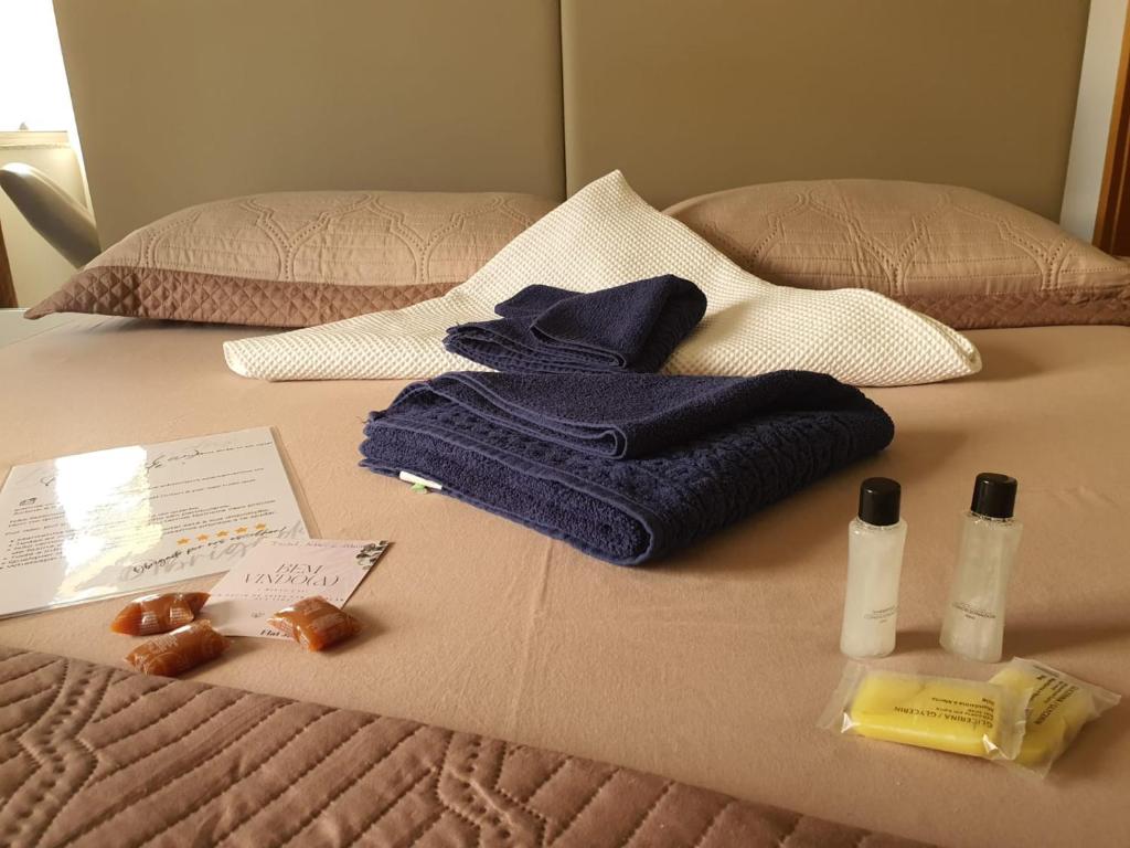 a bed with towels and other items on it at Suite Queen Deluxe BH in Belo Horizonte