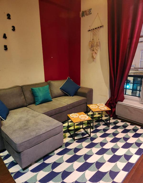 un salon avec un canapé et deux tables dans l'établissement Lagny sur marne, à Lagny-sur-Marne