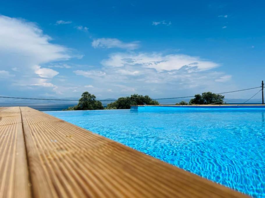 a pool with blue water and a bridge in the background at Kalyva Country House, with private beach and pool in Benitses