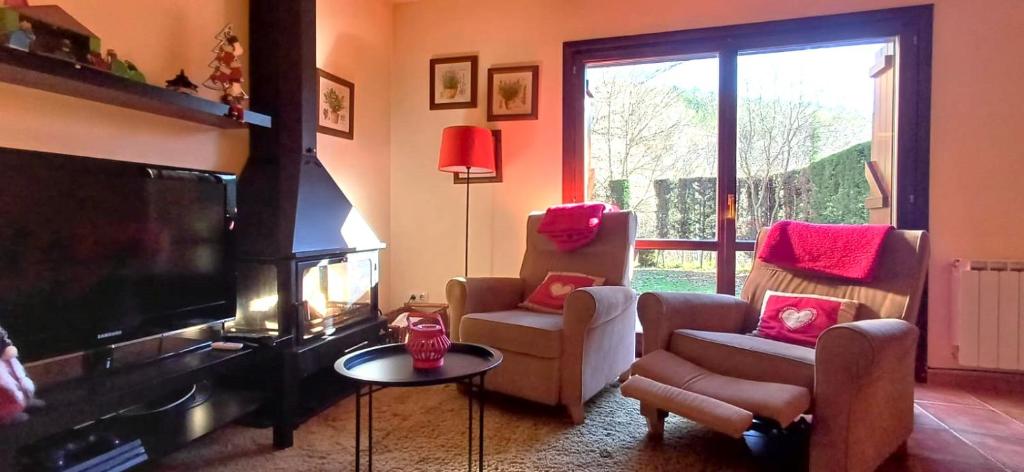 卡斯鐵略德哈卡的住宿－Molino21 Castiello de Jaca，客厅配有平面电视和2把椅子