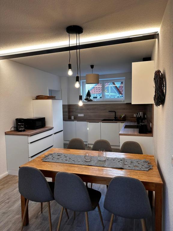 uma cozinha com uma mesa de madeira e cadeiras em Landhof Belka em Hoyerswerda