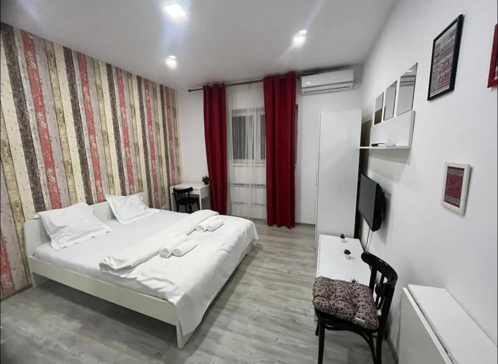 a bedroom with a white bed and a red curtain at Amazing location in the city center in Bucharest